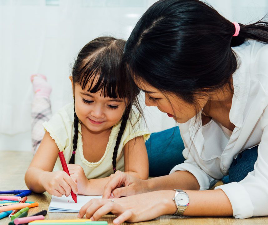 child writing with adult helping